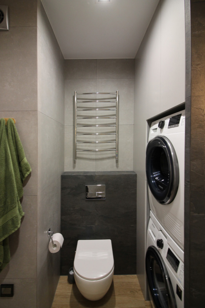 Photo of a small contemporary ensuite bathroom in Saint Petersburg with flat-panel cabinets, a submerged bath, a shower/bath combination, a wall mounted toilet, black tiles, porcelain tiles, grey walls, porcelain flooring, a built-in sink, wooden worktops, beige floors, a shower curtain, beige worktops, a laundry area, a single sink and a floating vanity unit.