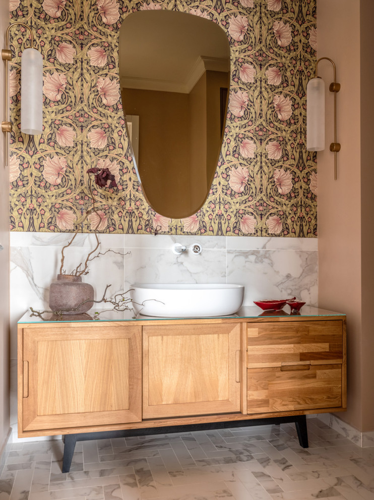 Idée de décoration pour une salle de bain tradition en bois brun de taille moyenne avec un carrelage blanc, un mur rose, une vasque, un plan de toilette en verre, un sol blanc et un placard à porte shaker.