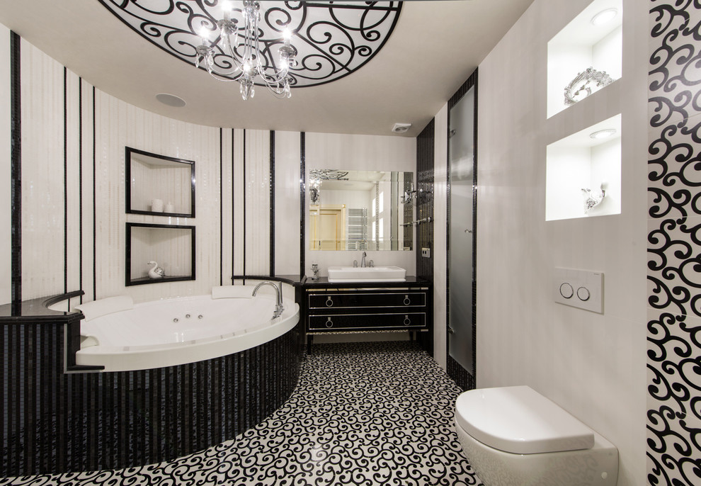 Aménagement d'une douche en alcôve principale classique avec des portes de placard noires, WC suspendus, un carrelage noir et blanc, un mur blanc, une vasque et un bain bouillonnant.