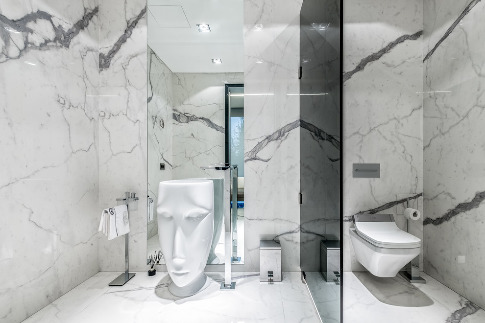 На фото: огромная ванная комната в современном стиле с инсталляцией, серой плиткой, белой плиткой, плиткой из листового камня, раковиной с пьедесталом и белым полом с