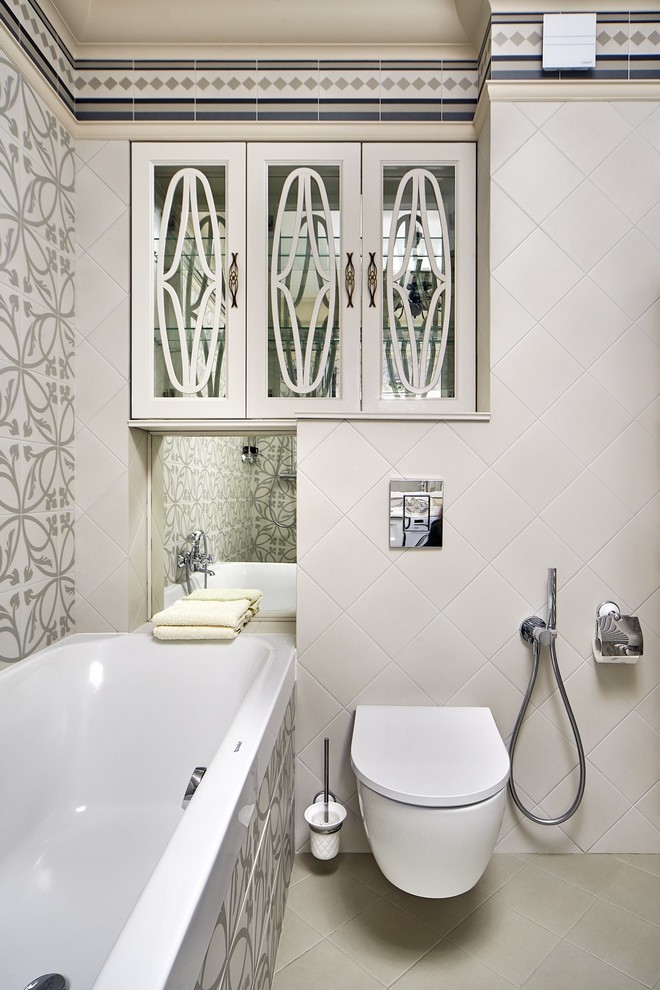 На фото: главная ванная комната в стиле неоклассика (современная классика) с ванной в нише, инсталляцией, серой плиткой, бежевой плиткой, бежевым полом и гигиеническим душем