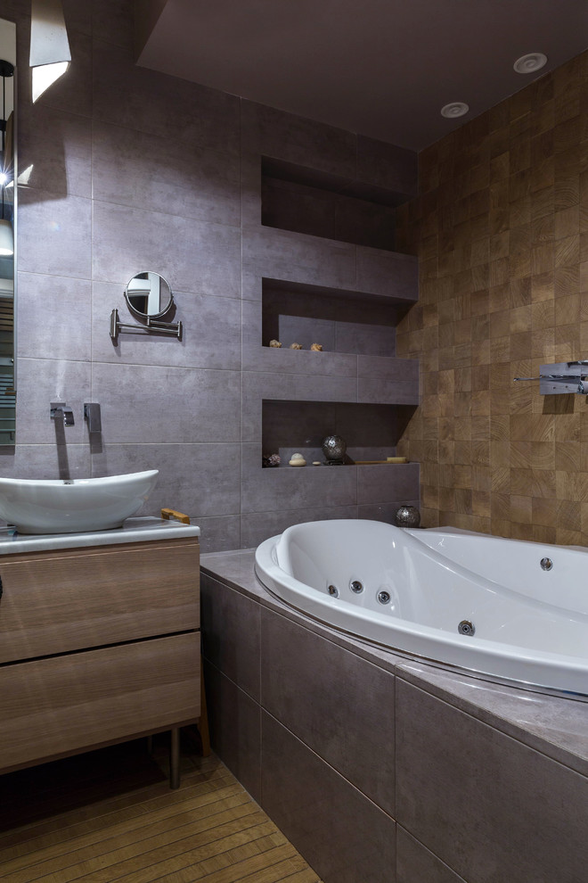 Imagen de cuarto de baño contemporáneo con jacuzzi, baldosas y/o azulejos de porcelana, paredes grises, suelo de madera pintada y suelo marrón