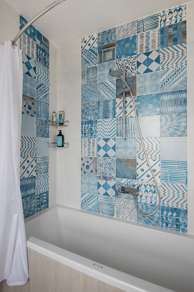 Foto de cuarto de baño costero con bañera encastrada, combinación de ducha y bañera, baldosas y/o azulejos azules, baldosas y/o azulejos multicolor y ducha con cortina