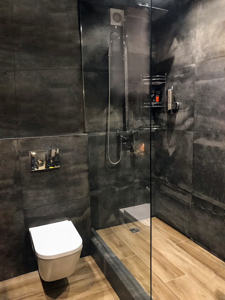 Idéer för ett litet industriellt brun badrum med dusch, med en vägghängd toalettstol, svart kakel, svarta väggar, träbänkskiva, skåp i mellenmörkt trä, en hörndusch, ett fristående handfat, släta luckor, porslinskakel, brunt golv och dusch med duschdraperi