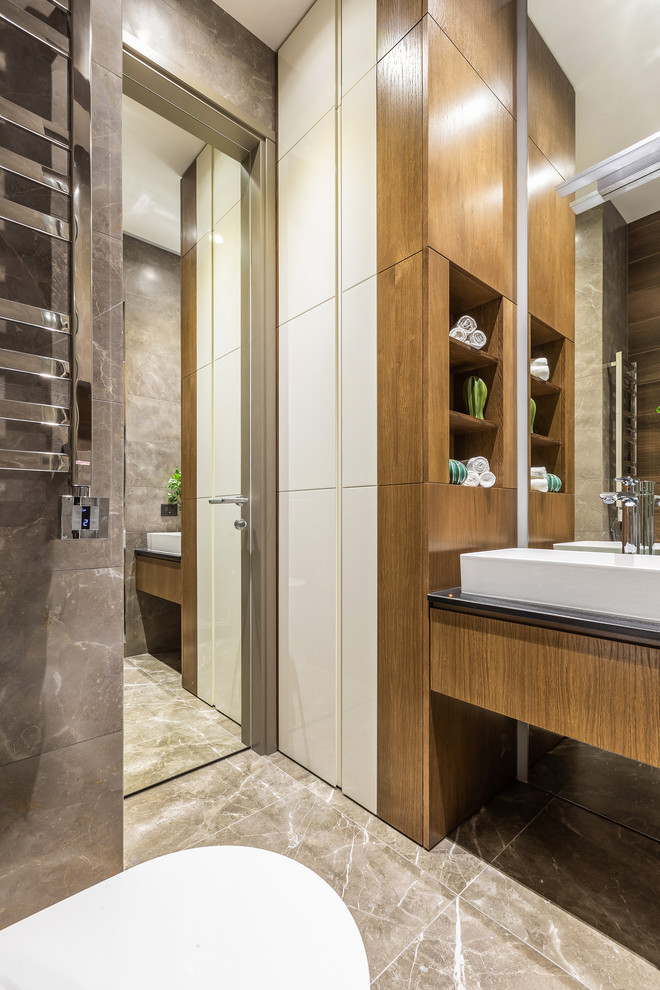 Esempio di una stanza da bagno contemporanea con ante lisce, ante in legno scuro, lavabo a bacinella, pavimento grigio e top nero