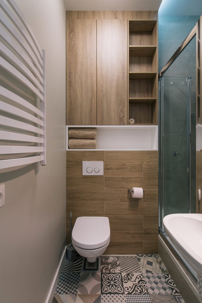 Foto på ett litet funkis badrum med dusch, med släta luckor, beige skåp, en dusch i en alkov, en vägghängd toalettstol, beige kakel, keramikplattor, grå väggar, klinkergolv i keramik, ett väggmonterat handfat, flerfärgat golv och dusch med skjutdörr
