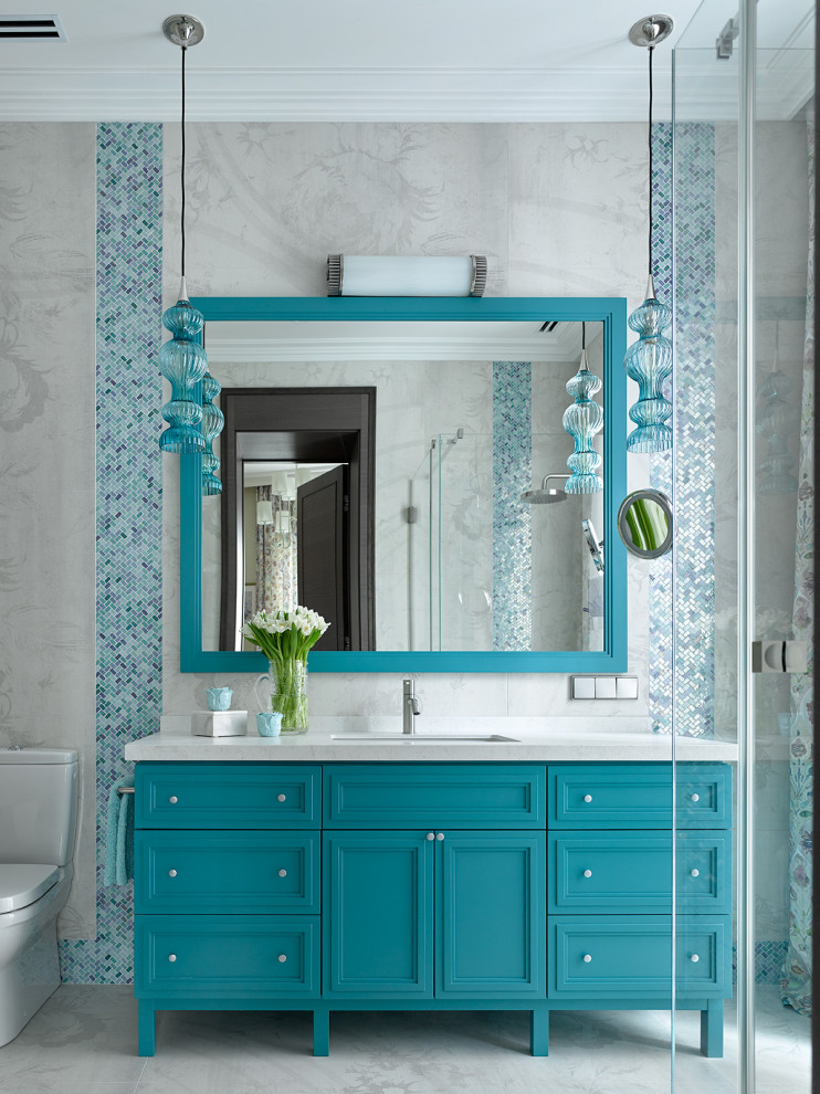 Réalisation d'une salle de bain design avec un placard avec porte à panneau encastré, des portes de placard turquoises, un lavabo encastré, un sol gris, un plan de toilette blanc et meuble simple vasque.