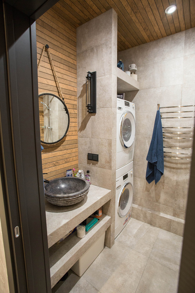 This is an example of a medium sized urban ensuite bathroom in Saint Petersburg with flat-panel cabinets, grey cabinets, an alcove bath, a shower/bath combination, grey tiles, porcelain tiles, brown walls, porcelain flooring, a vessel sink, tiled worktops, grey floors, a shower curtain and grey worktops.