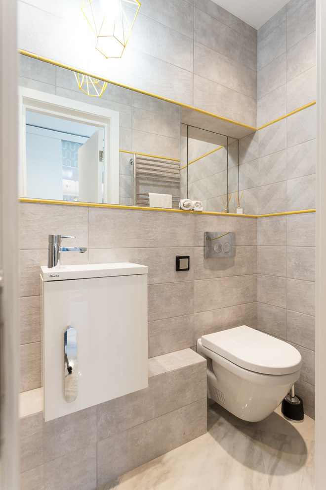 Cette photo montre une salle d'eau tendance avec un placard à porte plane, des portes de placard blanches, WC suspendus, un carrelage beige, un lavabo intégré et un sol beige.