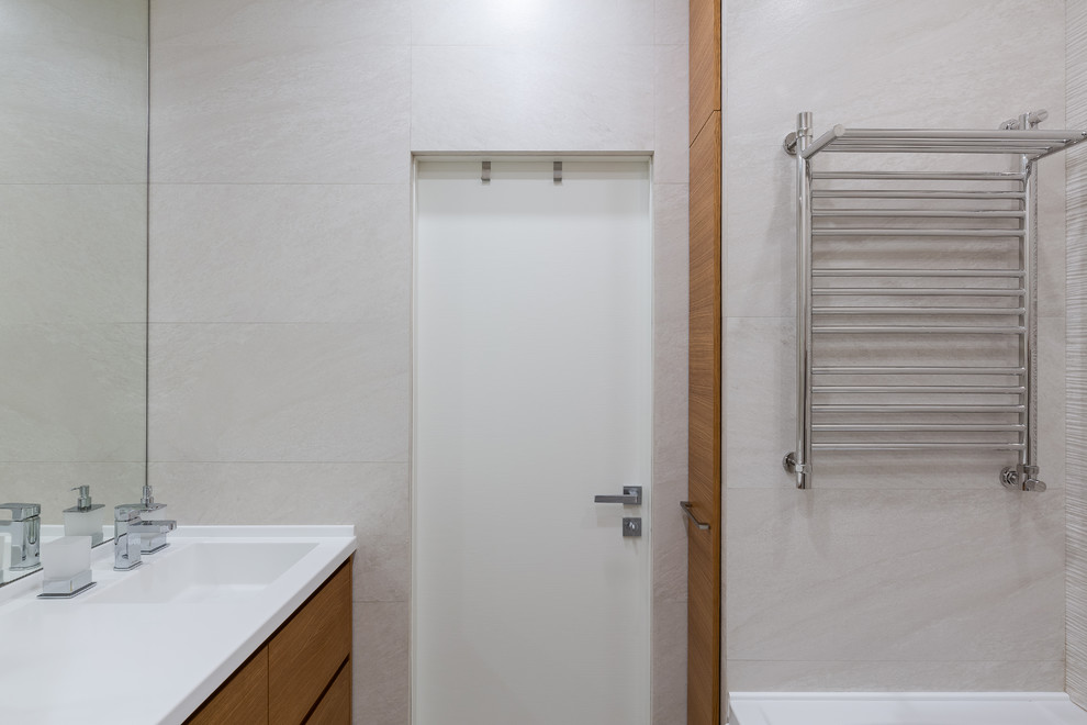 Inredning av ett modernt litet vit vitt badrum, med släta luckor, skåp i mellenmörkt trä, ett fristående badkar, en dusch/badkar-kombination, en vägghängd toalettstol, beige kakel, porslinskakel, beige väggar, klinkergolv i porslin, ett integrerad handfat, bänkskiva i akrylsten och beiget golv