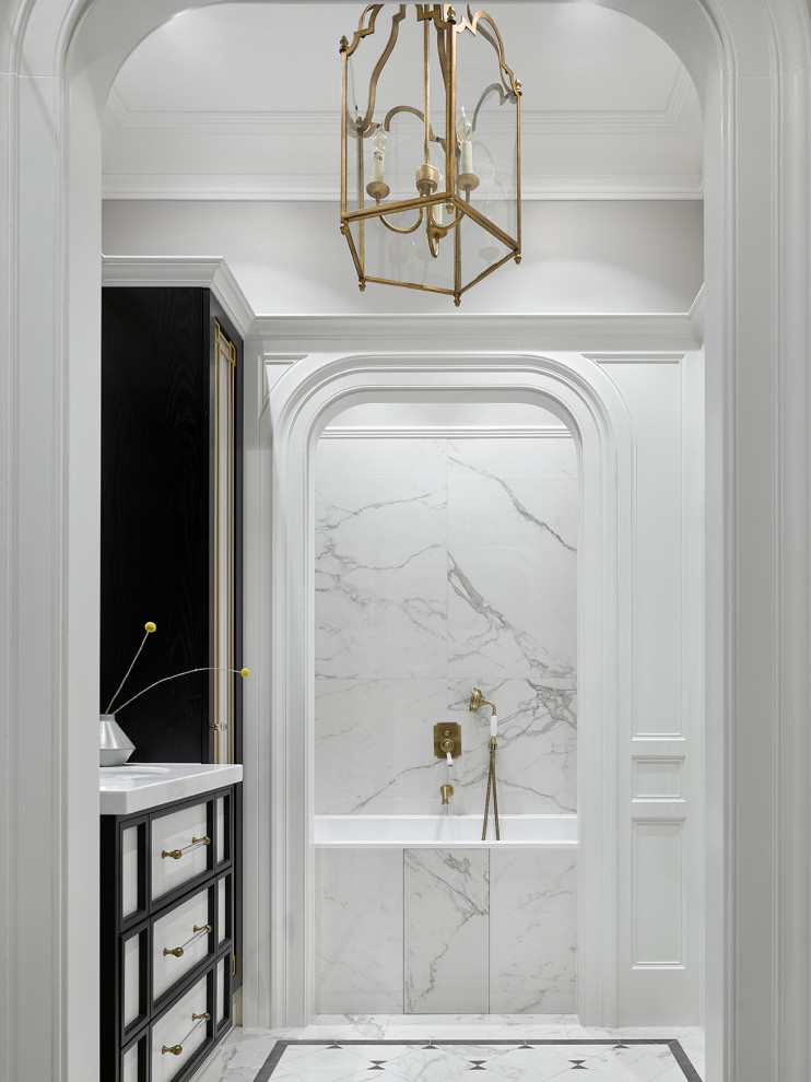 Идея дизайна: ванная комната в стиле неоклассика (современная классика) с ванной в нише, душем над ванной, белыми стенами, белым полом, белой столешницей, тумбой под одну раковину и напольной тумбой