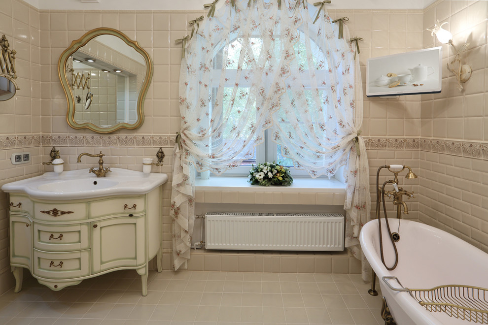 Ispirazione per una stanza da bagno tradizionale di medie dimensioni con vasca freestanding, piastrelle beige, piastrelle in ceramica, pavimento con piastrelle in ceramica, lavabo integrato, ante in stile shaker e ante bianche