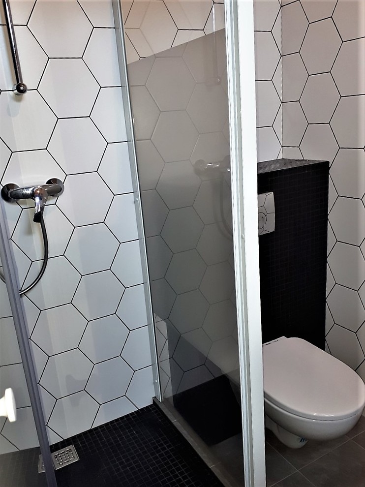 Идея дизайна: ванная комната в скандинавском стиле с инсталляцией, черно-белой плиткой, керамической плиткой, серыми стенами, полом из керамической плитки, серым полом и душем с распашными дверями