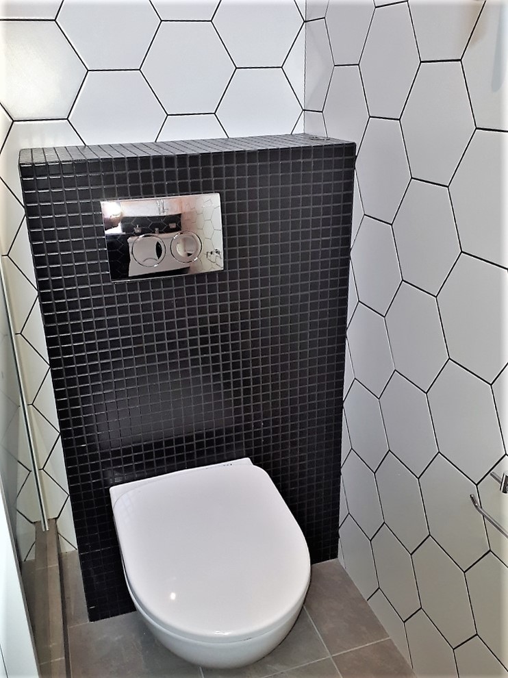 Immagine di una stanza da bagno scandinava con WC sospeso, pistrelle in bianco e nero, pavimento con piastrelle in ceramica, pavimento grigio e porta doccia scorrevole