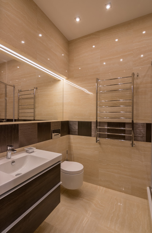 Esempio di una stanza da bagno minimal di medie dimensioni con ante lisce, ante in legno bruno, WC sospeso, piastrelle beige, piastrelle in gres porcellanato, pavimento in travertino, top in superficie solida e lavabo integrato