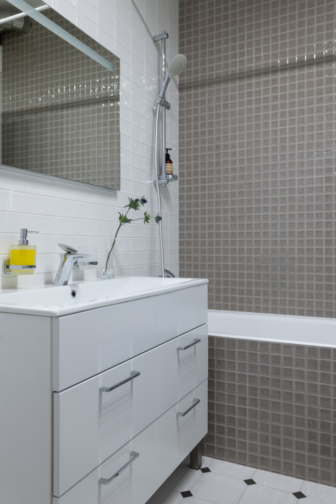 На фото: ванная комната в современном стиле с плоскими фасадами, белыми фасадами, ванной в нише, душем над ванной, серой плиткой, плиткой мозаикой, консольной раковиной, белым полом, шторкой для ванной и зеркалом с подсветкой с