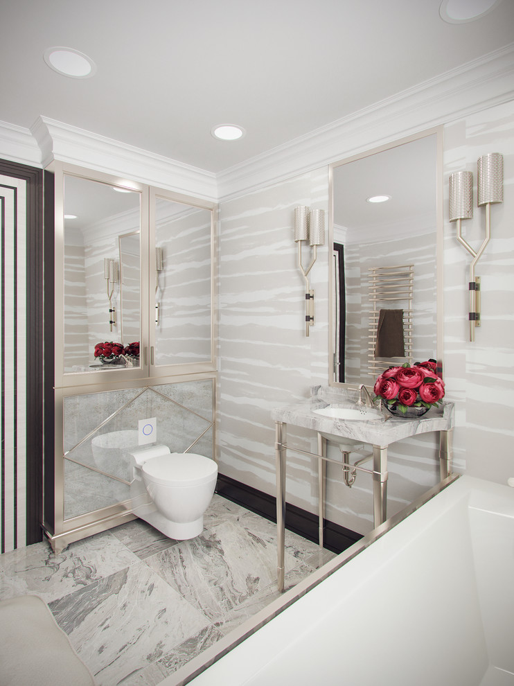 Foto di una piccola stanza da bagno con doccia design con ante lisce, ante in legno chiaro, vasca da incasso, vasca/doccia, WC sospeso, piastrelle grigie, piastrelle in gres porcellanato, pareti grigie, pavimento in gres porcellanato, lavabo a consolle e top in marmo