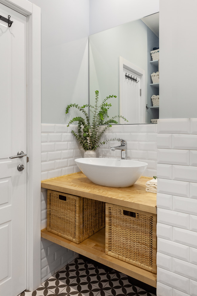 Immagine di una stanza da bagno padronale scandinava con vasca sottopiano, vasca/doccia, piastrelle bianche, piastrelle in gres porcellanato, pavimento in gres porcellanato, lavabo da incasso e top in legno