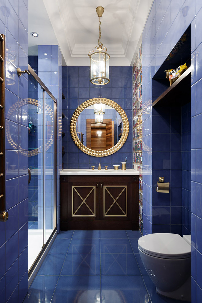 Cette photo montre une grande salle de bain chic en bois foncé avec un mur bleu, WC à poser, un carrelage bleu, un placard avec porte à panneau surélevé, des carreaux de céramique, un sol en carrelage de céramique, une vasque, un plan de toilette en marbre et une cabine de douche à porte coulissante.