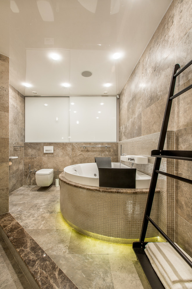 Exemple d'une salle de bain principale tendance avec un bain bouillonnant, un combiné douche/baignoire, WC suspendus, un carrelage beige et un mur beige.