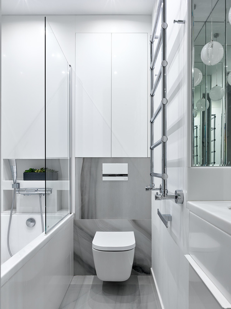 Foto de cuarto de baño principal contemporáneo de tamaño medio con sanitario de pared, paredes blancas, suelo gris y encimeras blancas