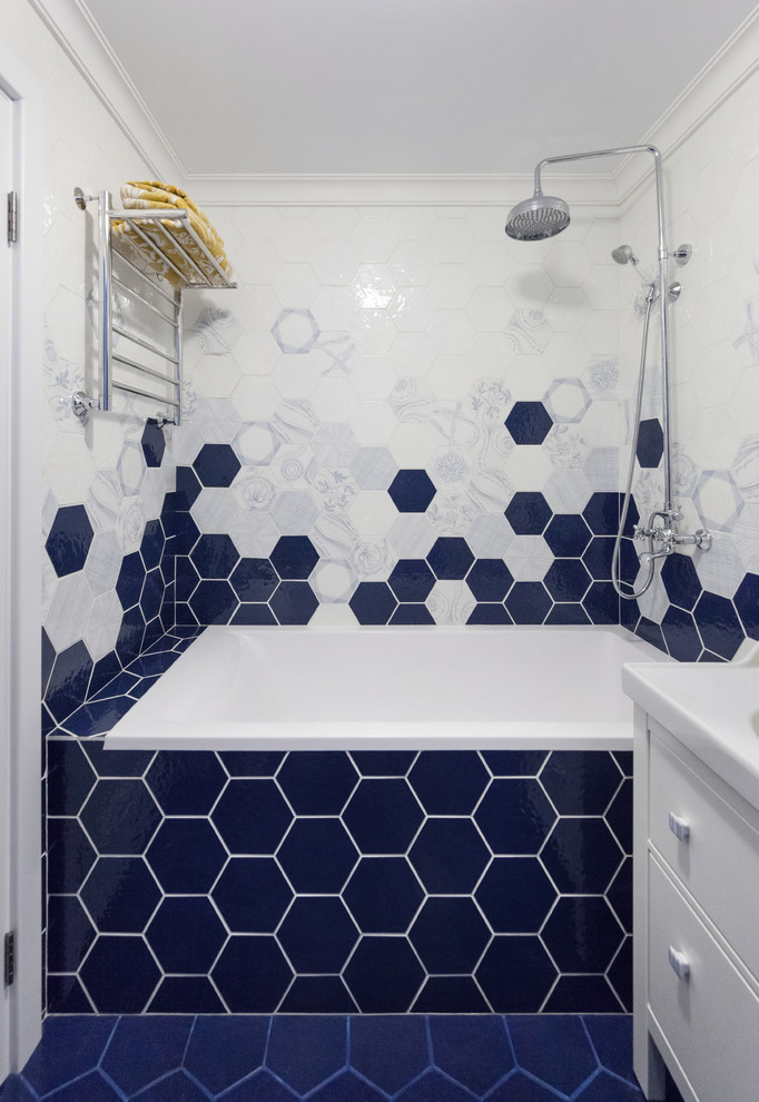 Modelo de cuarto de baño principal actual con bañera empotrada, combinación de ducha y bañera, lavabo integrado y suelo azul
