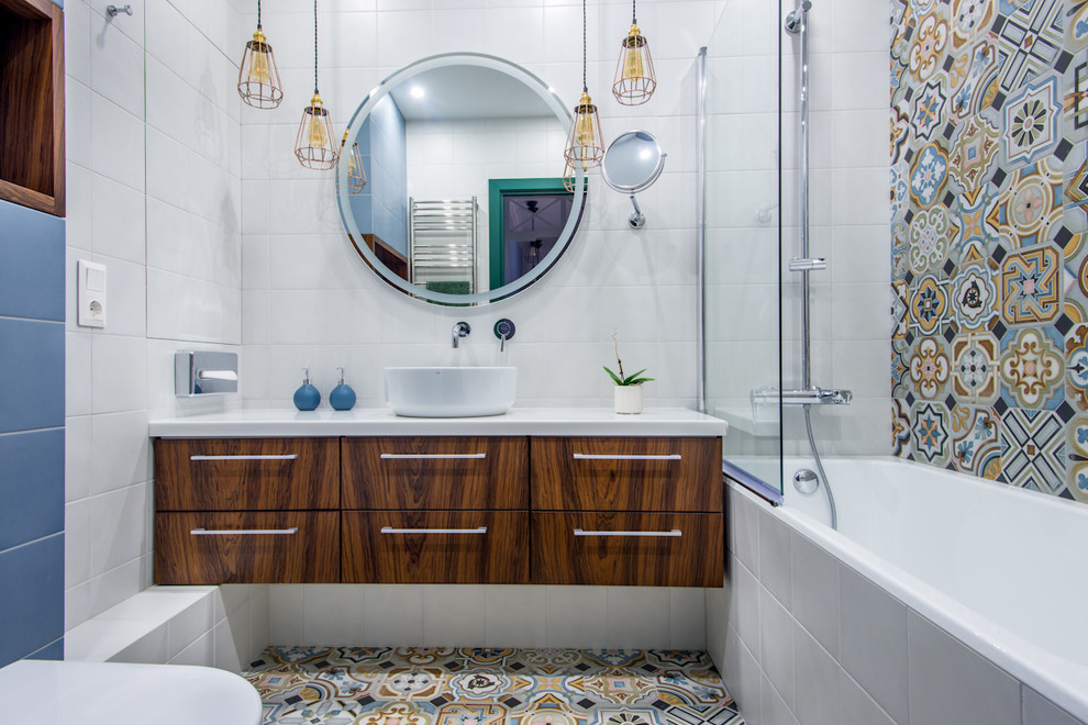 Стильный дизайн: ванная комната в современном стиле с плоскими фасадами, темными деревянными фасадами, ванной в нише, душем над ванной, инсталляцией, синей плиткой, разноцветной плиткой, белой плиткой, цементной плиткой, разноцветными стенами, полом из цементной плитки, душевой кабиной, настольной раковиной, разноцветным полом и открытым душем - последний тренд