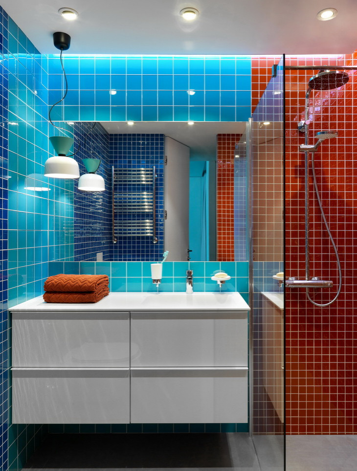 На фото: ванная комната среднего размера в современном стиле с плоскими фасадами, белыми фасадами, открытым душем, инсталляцией, оранжевой плиткой, стеклянной плиткой, синими стенами, полом из керамогранита, душевой кабиной, монолитной раковиной, столешницей из искусственного камня, серым полом, шторкой для ванной, белой столешницей, тумбой под одну раковину и подвесной тумбой