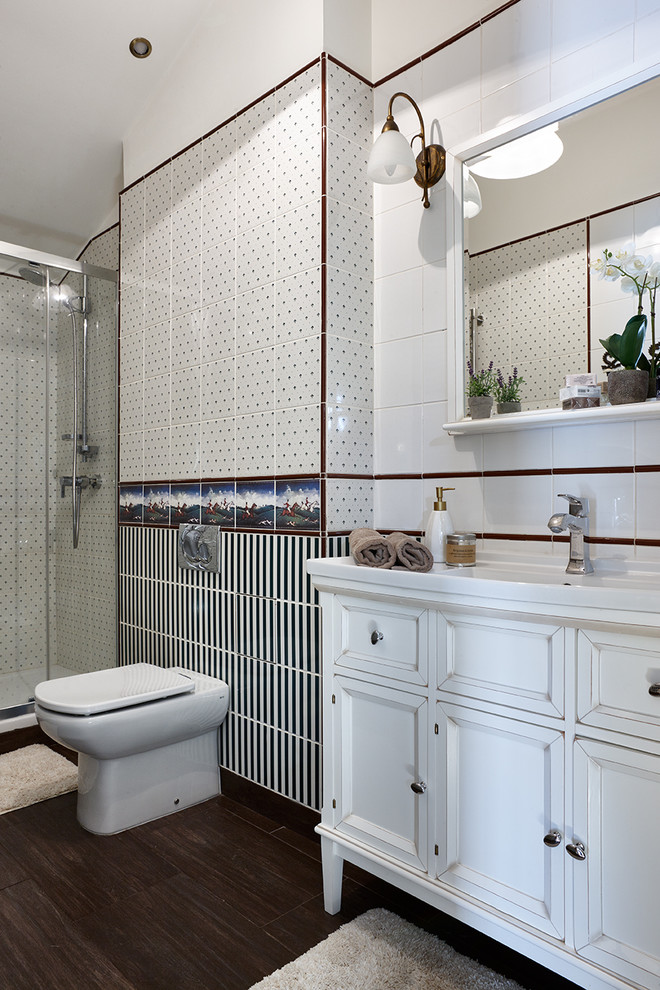 Imagen de cuarto de baño actual con sanitario de dos piezas, baldosas y/o azulejos blancos, baldosas y/o azulejos blancas y negros, aseo y ducha y lavabo integrado