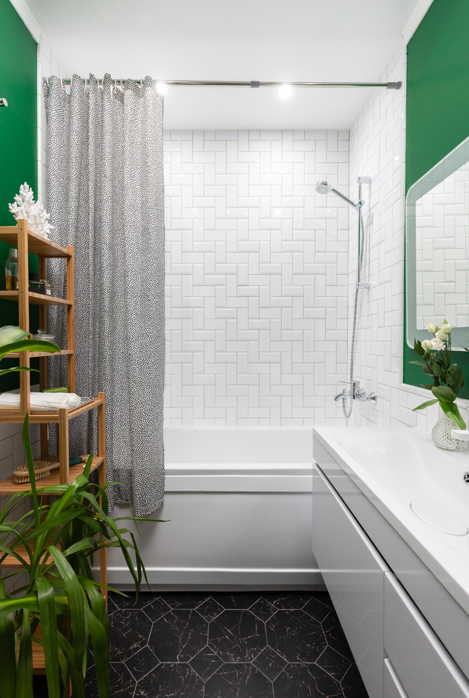 На фото: главная ванная комната в современном стиле с плоскими фасадами, белыми фасадами, ванной в нише, зелеными стенами, черным полом, шторкой для ванной, душем над ванной, белой плиткой, монолитной раковиной и белой столешницей с
