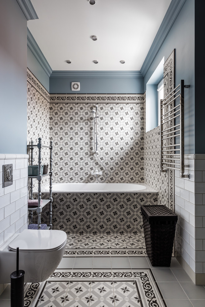 Immagine di una stanza da bagno padronale classica con vasca ad alcova, vasca/doccia, WC sospeso, piastrelle multicolore, piastrelle bianche, piastrelle grigie, pareti blu e pavimento multicolore