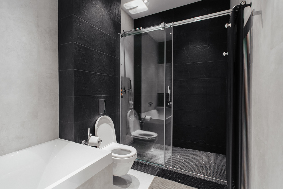Modelo de cuarto de baño actual pequeño con sanitario de pared, baldosas y/o azulejos negros, baldosas y/o azulejos de cerámica, paredes blancas, suelo de baldosas de cerámica y lavabo encastrado