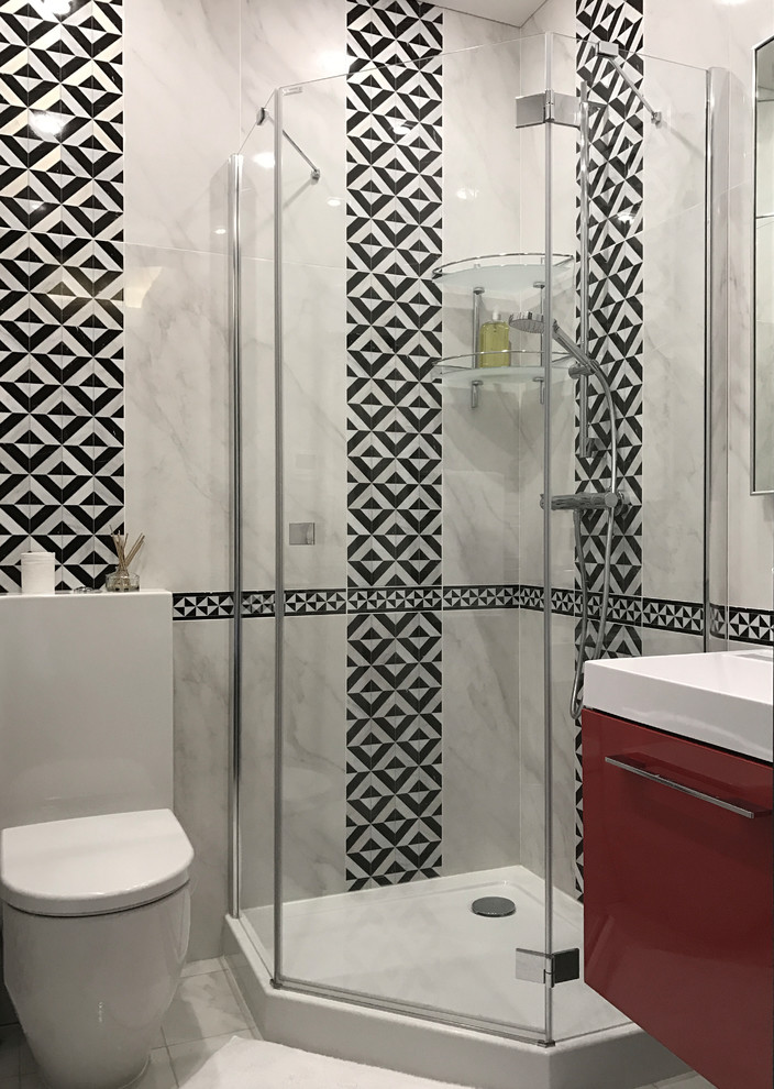 Foto på ett funkis badrum, med en hörndusch, grå kakel, dusch med gångjärnsdörr, släta luckor och röda skåp