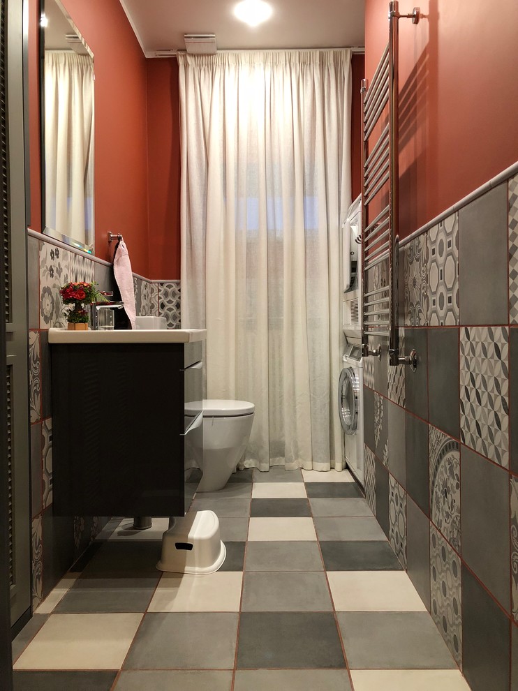 На фото: ванная комната в классическом стиле с плоскими фасадами, черными фасадами, унитазом-моноблоком, серой плиткой, цементной плиткой, красными стенами, полом из цементной плитки, душевой кабиной, консольной раковиной, разноцветным полом и белой столешницей с