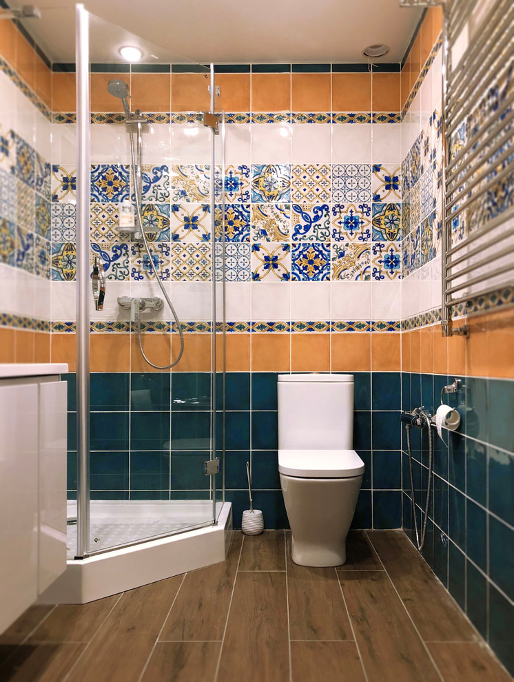 Exempel på ett modernt beige beige badrum med dusch, med släta luckor, beige skåp, en hörndusch, en toalettstol med hel cisternkåpa, blå kakel, brun kakel, grön kakel, flerfärgad kakel, vit kakel, keramikplattor, brunt golv och dusch med gångjärnsdörr