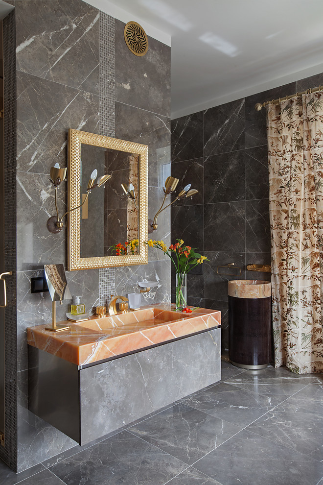Inredning av ett modernt stort en-suite badrum, med släta luckor, bruna skåp, ett fristående badkar, en dubbeldusch, en vägghängd toalettstol, brun kakel, stenkakel, bruna väggar, marmorgolv, ett väggmonterat handfat och bänkskiva i onyx