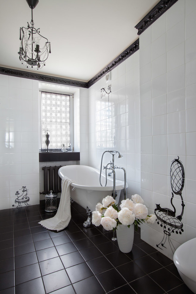 Foto på ett mellanstort vintage badrum, med svart och vit kakel, ett badkar med tassar och vita väggar