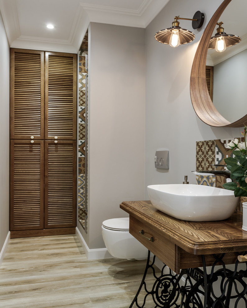 Example of a danish 3/4 beige tile and brown tile light wood floor and beige floor alcove shower design in Moscow with medium tone wood cabinets, a wall-mount toilet, gray walls, a vessel sink, wood countertops, brown countertops and a hinged shower door