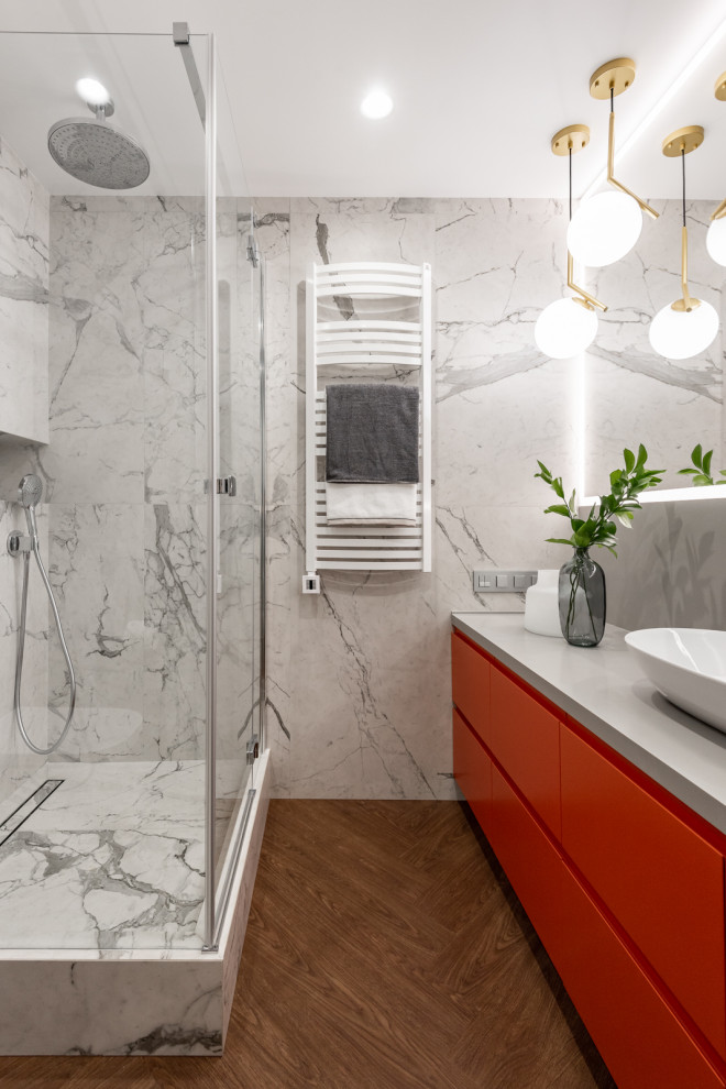Foto på ett stort funkis grå badrum med dusch, med släta luckor, röda skåp, en hörndusch, grå kakel, ett fristående handfat, brunt golv och dusch med gångjärnsdörr