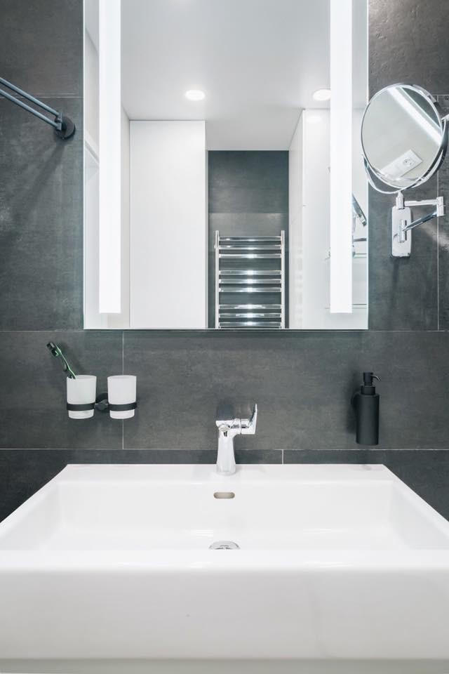 Inspiration för små moderna vitt badrum, med släta luckor, vita skåp, ett badkar i en alkov, en dusch/badkar-kombination, svart kakel, porslinskakel, svarta väggar, klinkergolv i porslin, ett nedsänkt handfat, bänkskiva i akrylsten, vitt golv och med dusch som är öppen