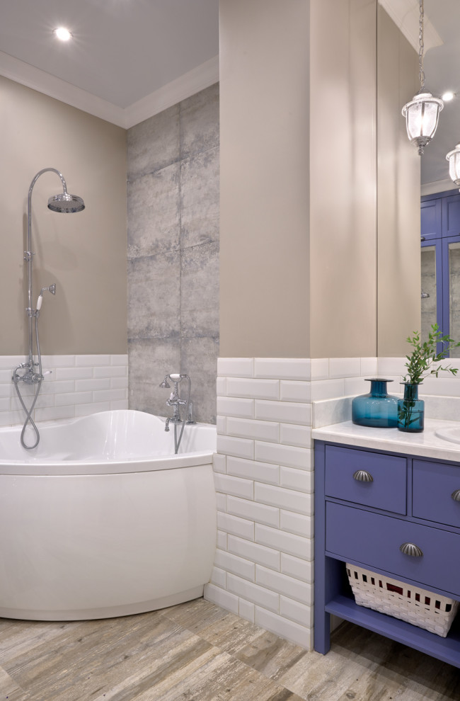 На фото: главная ванная комната в стиле неоклассика (современная классика) с плоскими фасадами, фиолетовыми фасадами, угловой ванной, бежевыми стенами, настольной раковиной и белой столешницей с