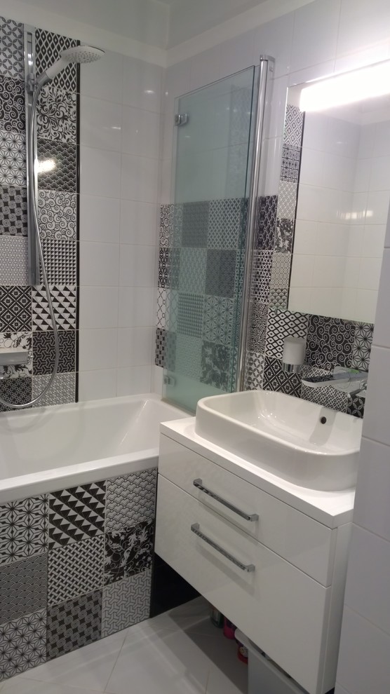 Inredning av ett modernt mellanstort en-suite badrum, med ett platsbyggt badkar, en dusch/badkar-kombination, en vägghängd toalettstol, svart och vit kakel, keramikplattor, vita väggar, klinkergolv i keramik och ett nedsänkt handfat