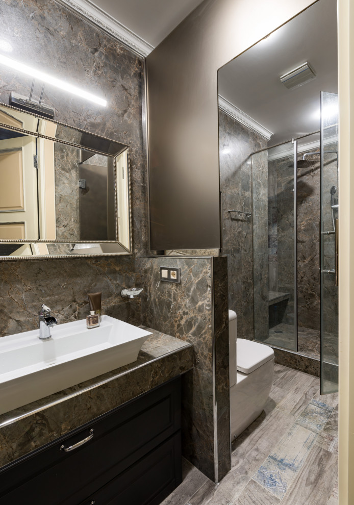 Idée de décoration pour une salle de bain design avec WC séparés, un carrelage marron, un mur marron, une vasque, un sol marron, un placard avec porte à panneau encastré, des portes de placard noires et un plan de toilette marron.