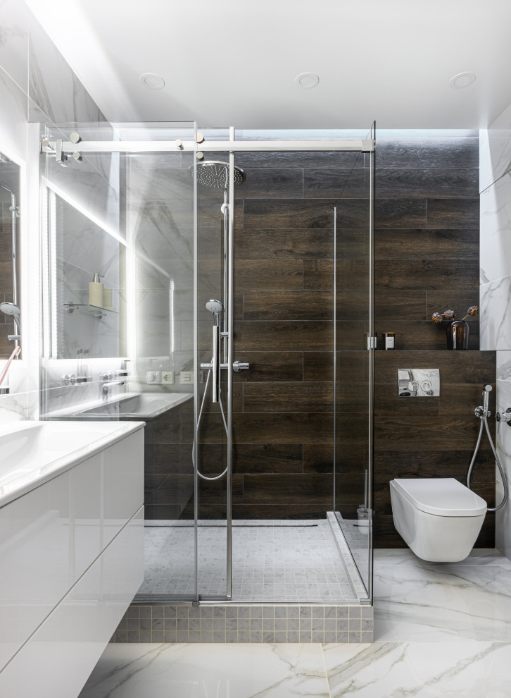 Foto di una stanza da bagno design con ante lisce, ante bianche, doccia ad angolo, WC sospeso, piastrelle marroni, lavabo a consolle, pavimento bianco e porta doccia scorrevole