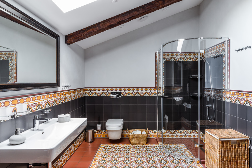 Стильный дизайн: ванная комната в современном стиле с угловым душем, коричневой плиткой, черной плиткой, белыми стенами, душевой кабиной, подвесной раковиной, разноцветным полом и душем с распашными дверями - последний тренд