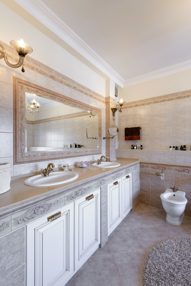 This is an example of a large classic ensuite bathroom in Novosibirsk with white cabinets, a claw-foot bath, beige tiles, ceramic tiles, beige walls, ceramic flooring, a submerged sink and solid surface worktops.