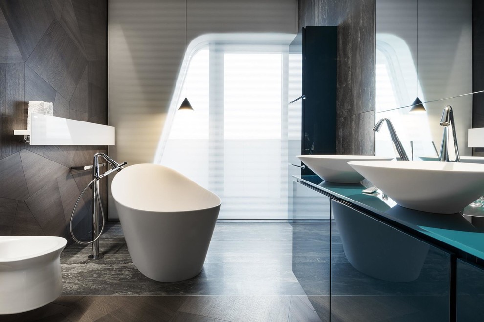 Photo of an expansive contemporary bathroom in Other with a freestanding bath, a shower/bath combination, a one-piece toilet, brown walls, a vessel sink, flat-panel cabinets, black cabinets and glass worktops.