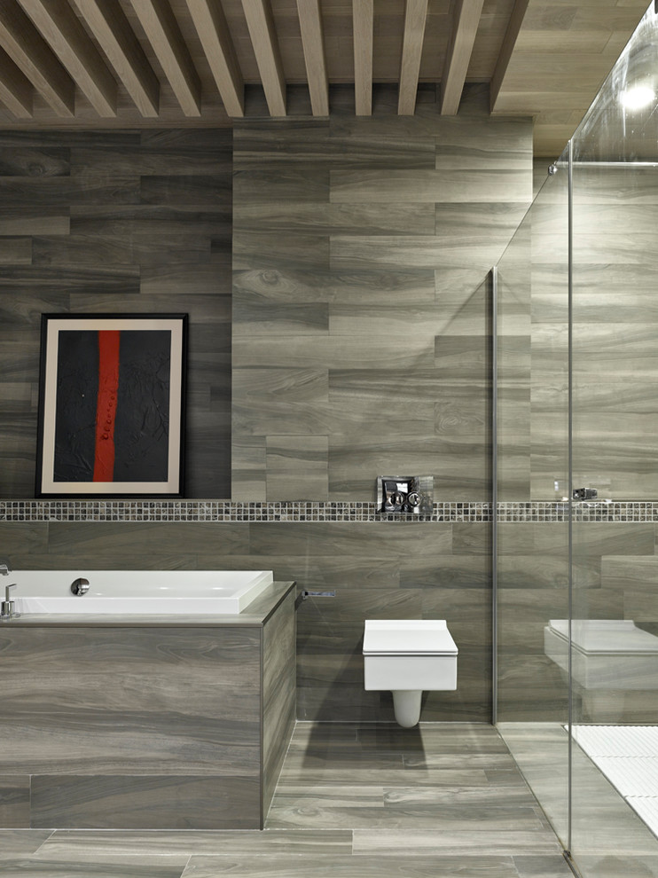 Aménagement d'une douche en alcôve principale contemporaine avec une baignoire posée, WC suspendus, un carrelage gris, un sol gris et un sol en carrelage de céramique.