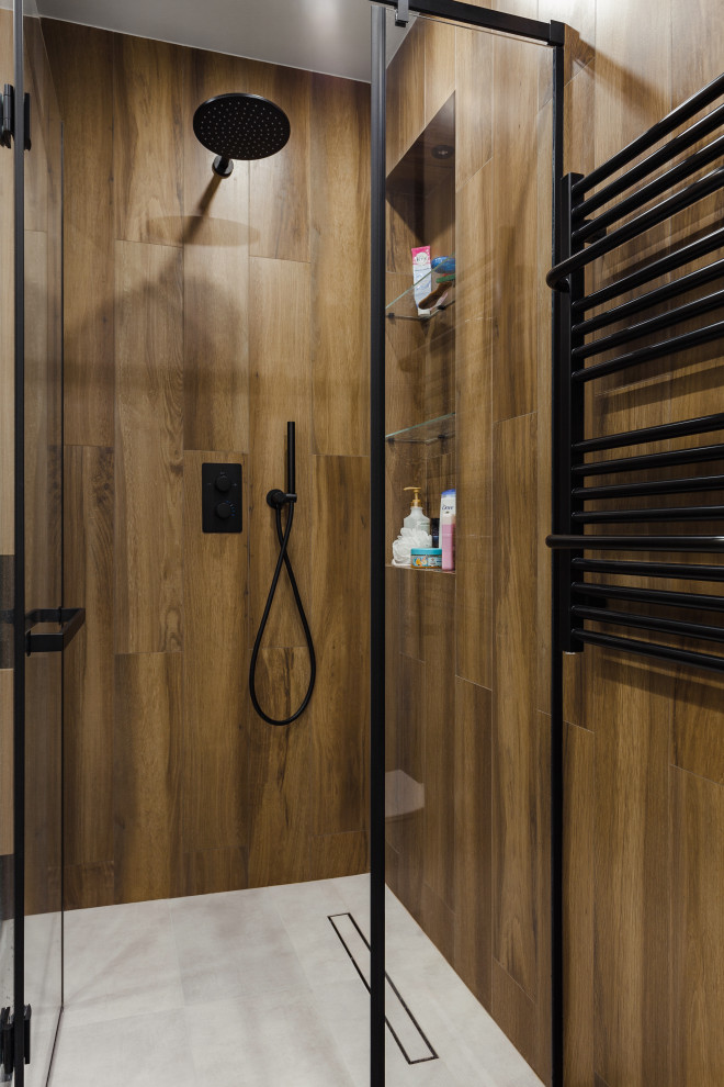 Пример оригинального дизайна: ванная комната среднего размера в современном стиле с плоскими фасадами, светлыми деревянными фасадами, угловым душем, инсталляцией, бежевой плиткой, плиткой под дерево, черными стенами, полом из керамогранита, душевой кабиной, серым полом и душем с распашными дверями