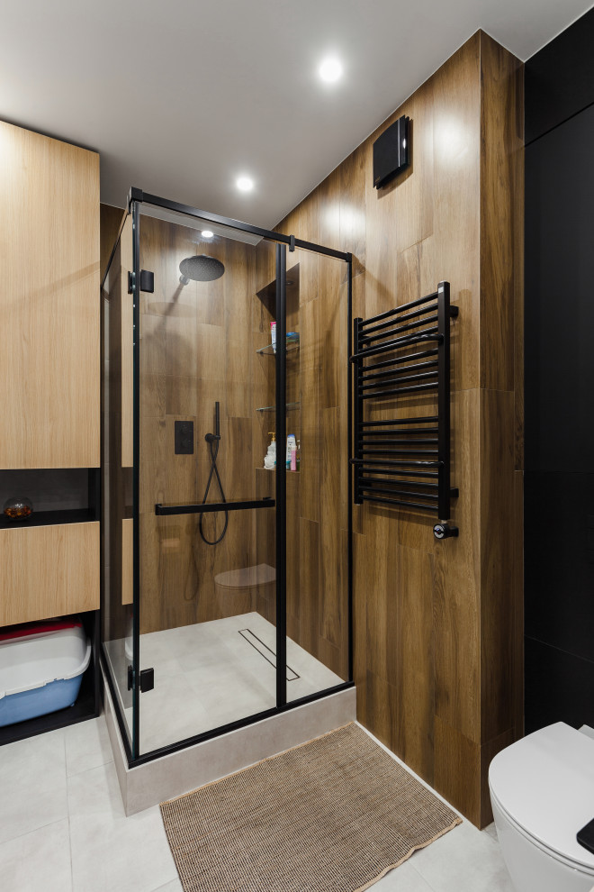 Идея дизайна: ванная комната среднего размера в современном стиле с плоскими фасадами, светлыми деревянными фасадами, угловым душем, инсталляцией, бежевой плиткой, плиткой под дерево, черными стенами, полом из керамогранита, душевой кабиной, серым полом и душем с распашными дверями
